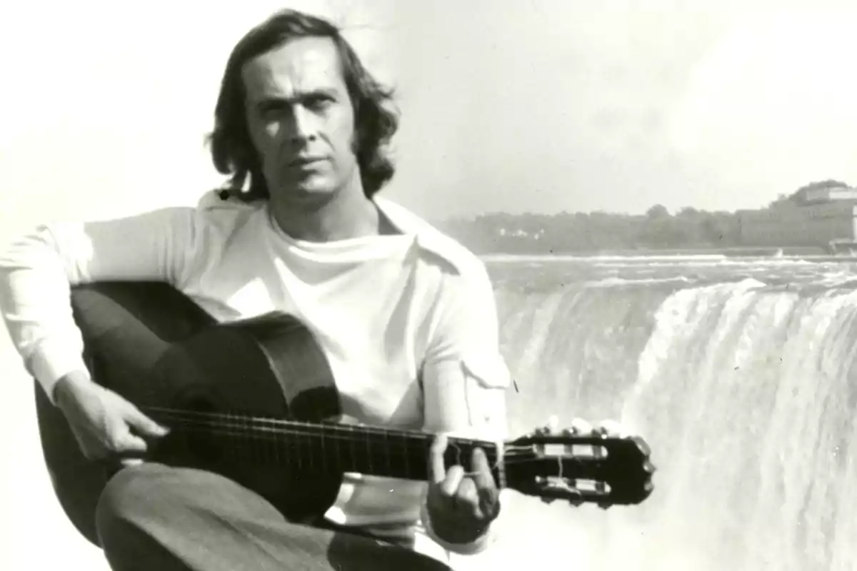 Hombre joven tocando una guitarra clásica frente a una gran cascada Hombre joven tocando una guitarra clásica frente a una gran cascada