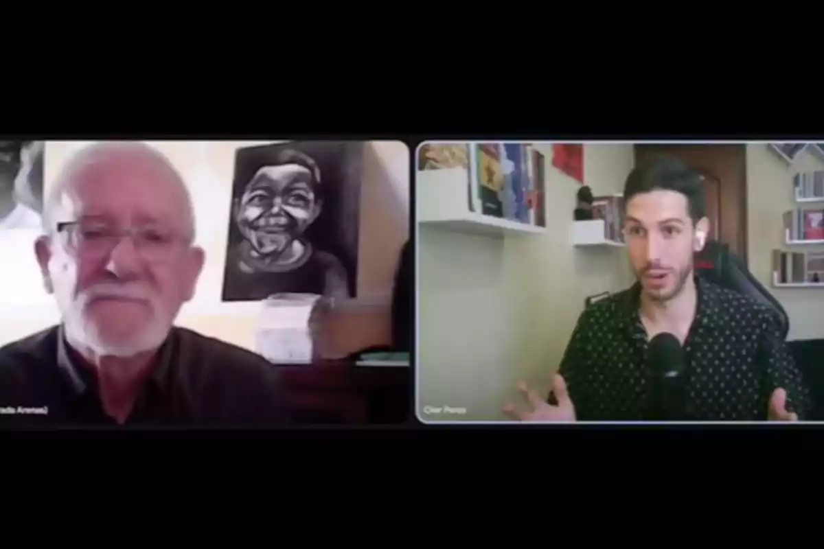 Dos hombres participan en una videollamada, uno de ellos es mayor y está frente a un cuadro en blanco y negro, mientras el otro es más joven y está en una habitación con estanterías y libros. Dos hombres participan en una videollamada, uno de ellos es mayor y está frente a un cuadro en blanco y negro, mientras el otro es más joven y está en una habitación con estanterías y libros.