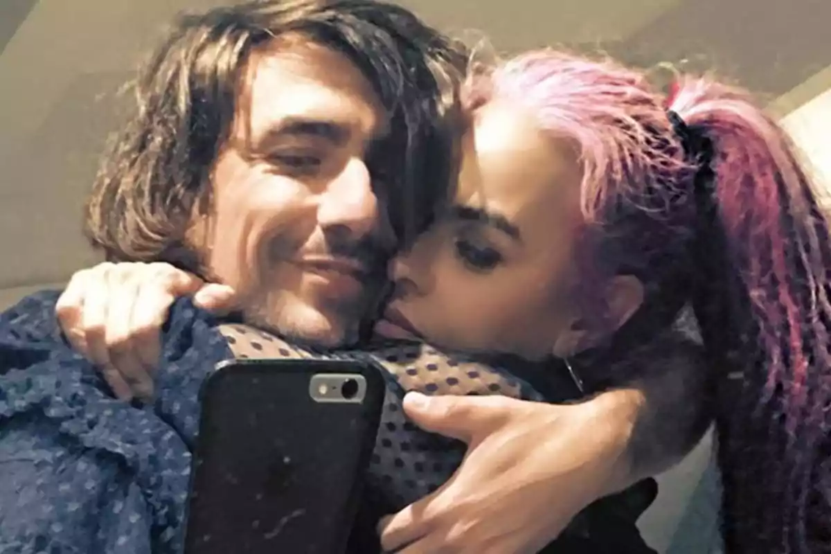 Pareja abrazándose y tomándose una selfie mientras sonríen y muestran cercanía Pareja abrazándose y tomándose una selfie mientras sonríen y muestran cercanía