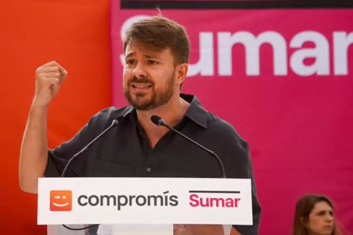 Hombre hablando en un mitin político de Compromís y Sumar con gesto enérgico y fondo rosa Hombre hablando en un mitin político de Compromís y Sumar con gesto enérgico y fondo rosa