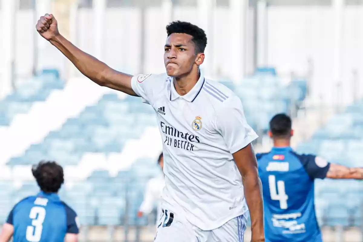 Futbolista del Real Madrid celebrando un gol con el puño en alto en un estadio Futbolista del Real Madrid celebrando un gol con el puño en alto en un estadio
