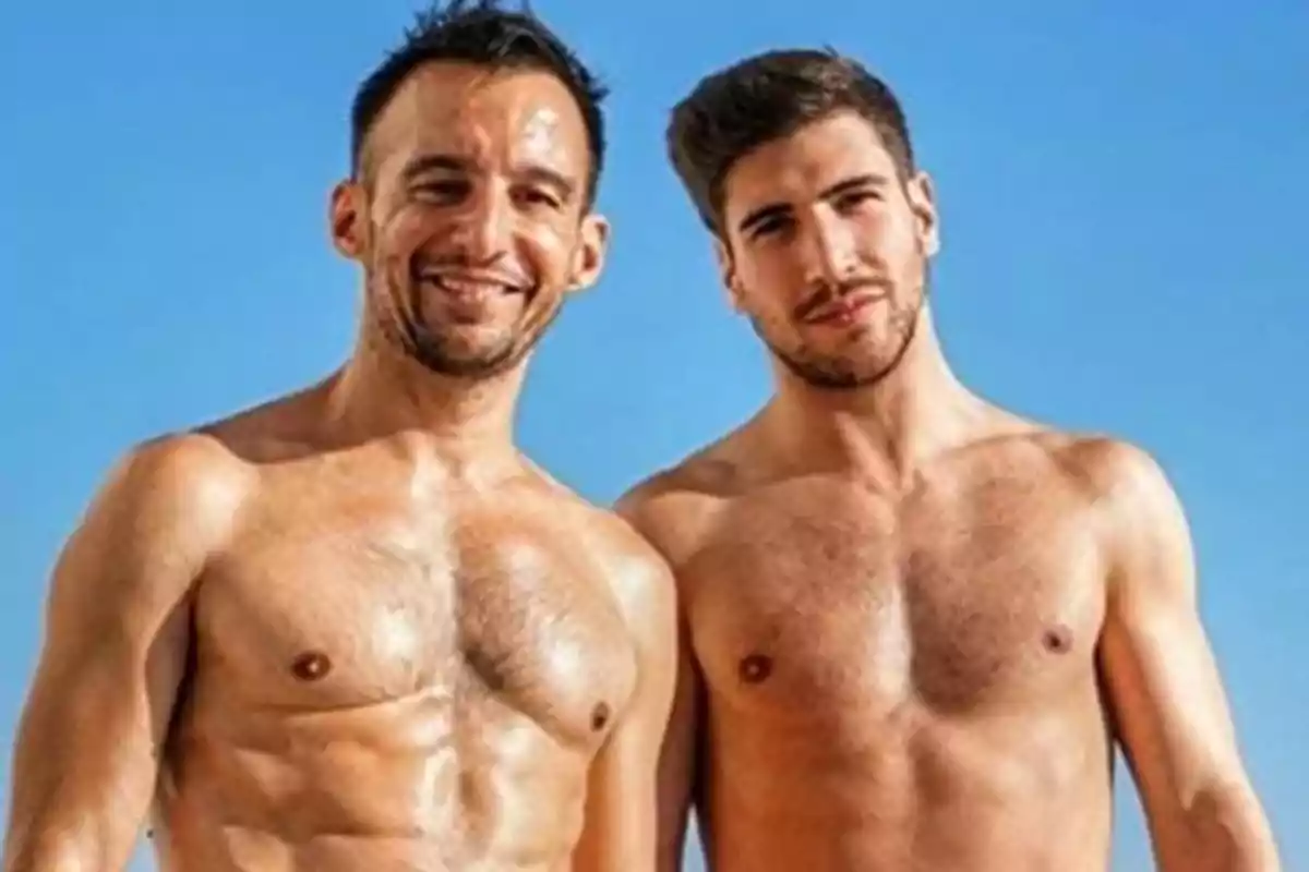Dos hombres jóvenes posan sin camiseta bajo un cielo azul Dos hombres jóvenes posan sin camiseta bajo un cielo azul