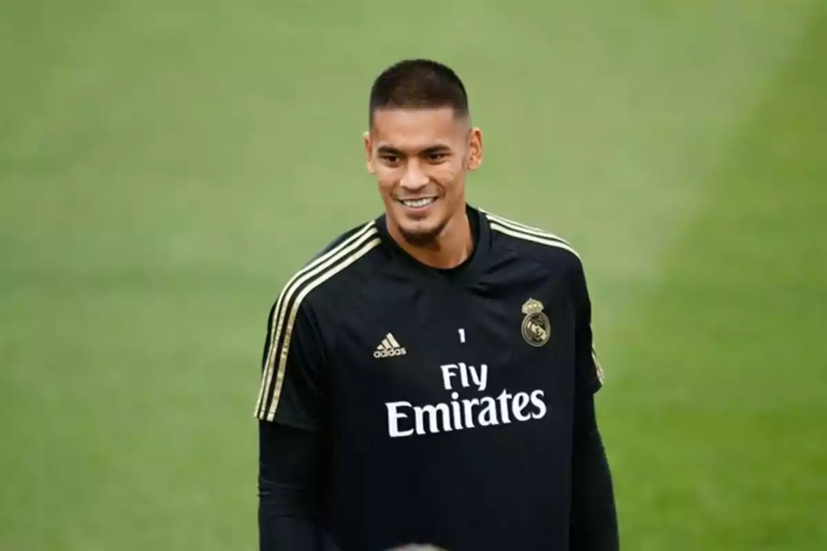 Futbolista con uniforme de entrenamiento negro del Real Madrid sonriendo en el campo de juego Futbolista con uniforme de entrenamiento negro del Real Madrid sonriendo en el campo de juego