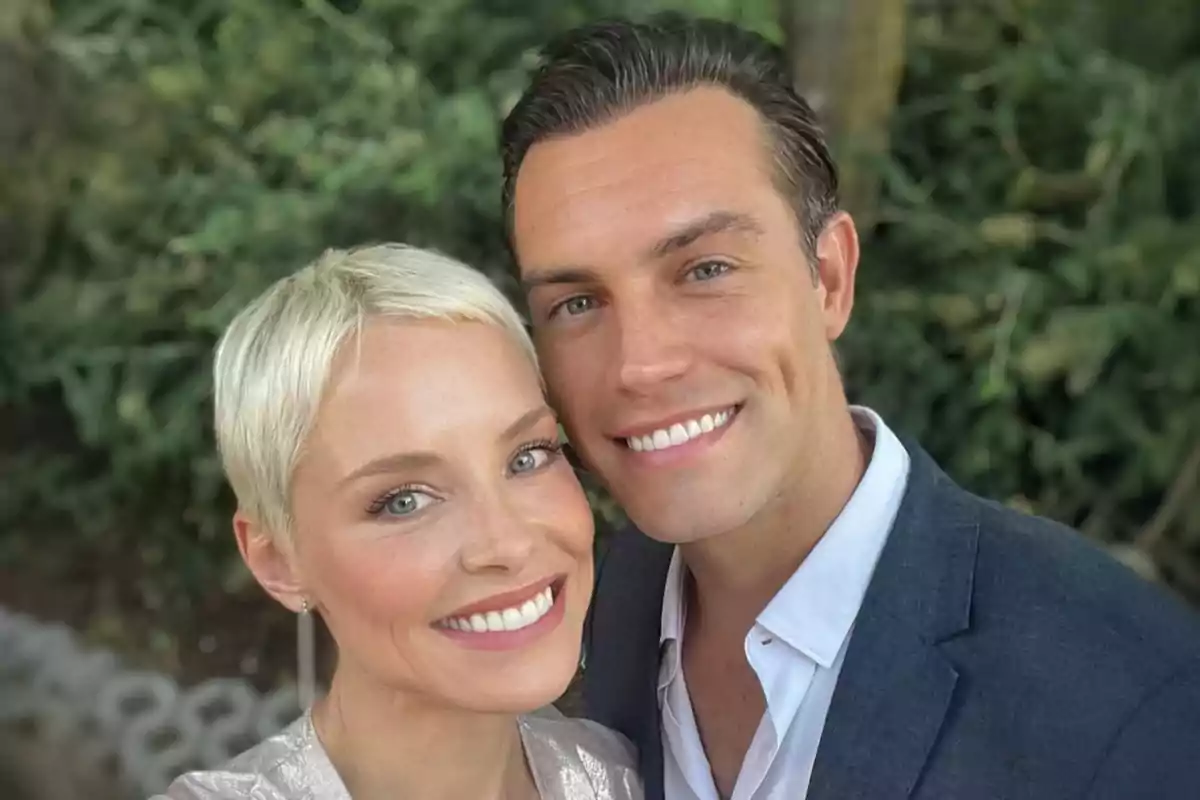 Pareja sonriente posando para una selfie al aire libre con fondo de vegetación