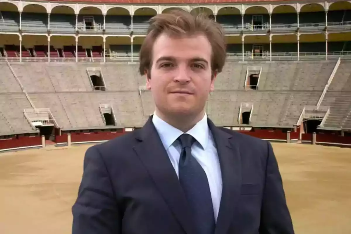 Hombre joven con traje y corbata posando en el centro de una plaza de toros vacía Hombre joven con traje y corbata posando en el centro de una plaza de toros vacía
