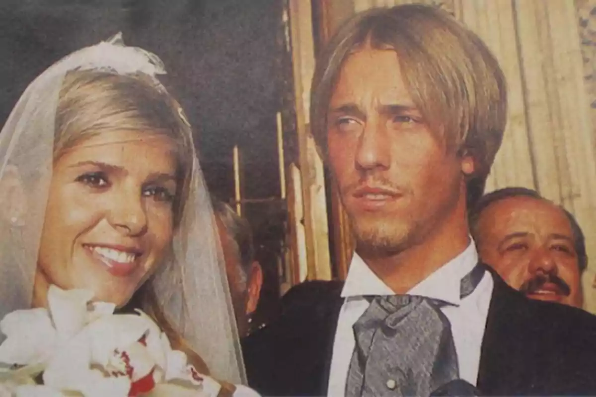 Pareja de recién casados sonríe durante su boda, la novia lleva velo y ramo de flores blancas, el novio viste traje formal Pareja de recién casados sonríe durante su boda, la novia lleva velo y ramo de flores blancas, el novio viste traje formal