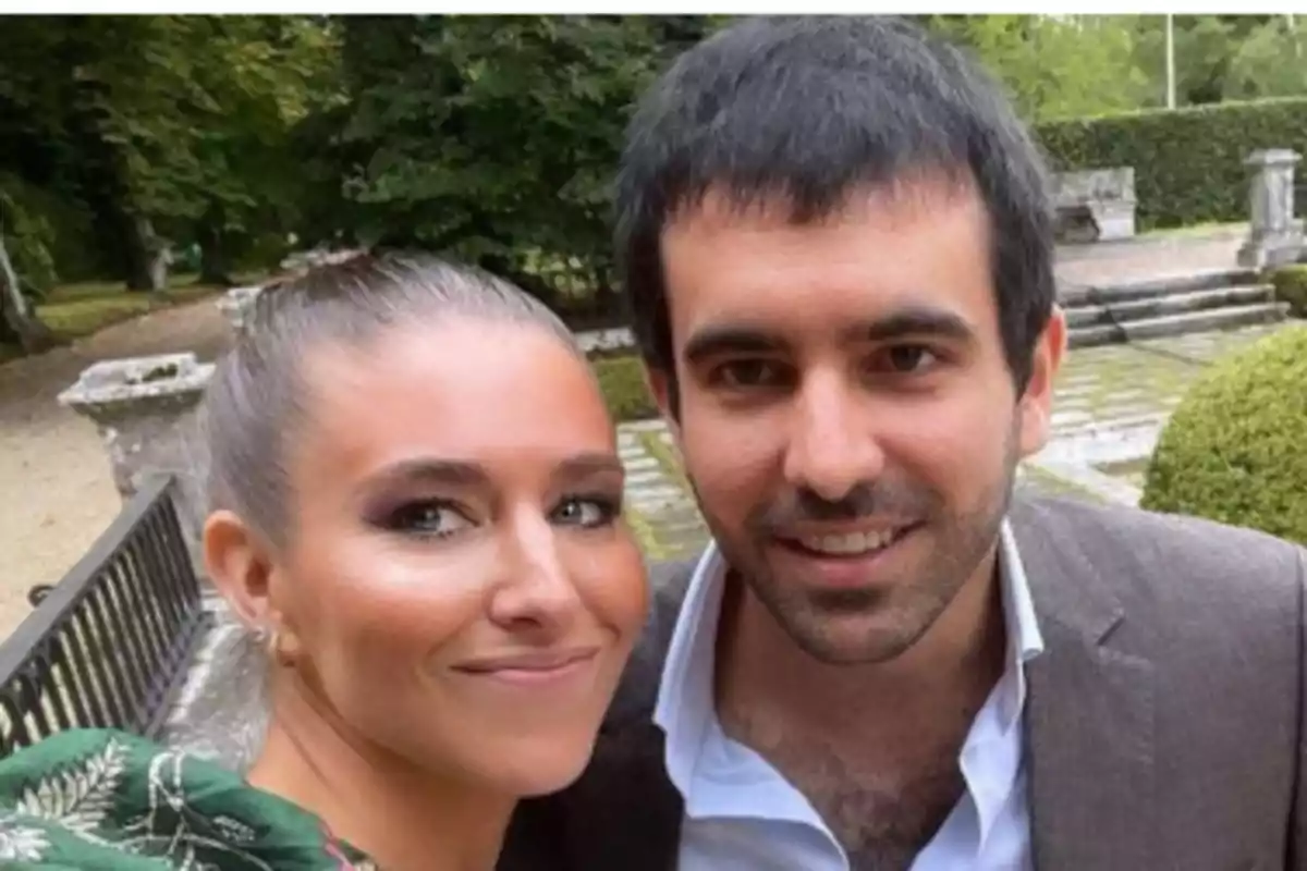 Una pareja sonríe mientras se toma una selfie en un jardín al aire libre Una pareja sonríe mientras se toma una selfie en un jardín al aire libre