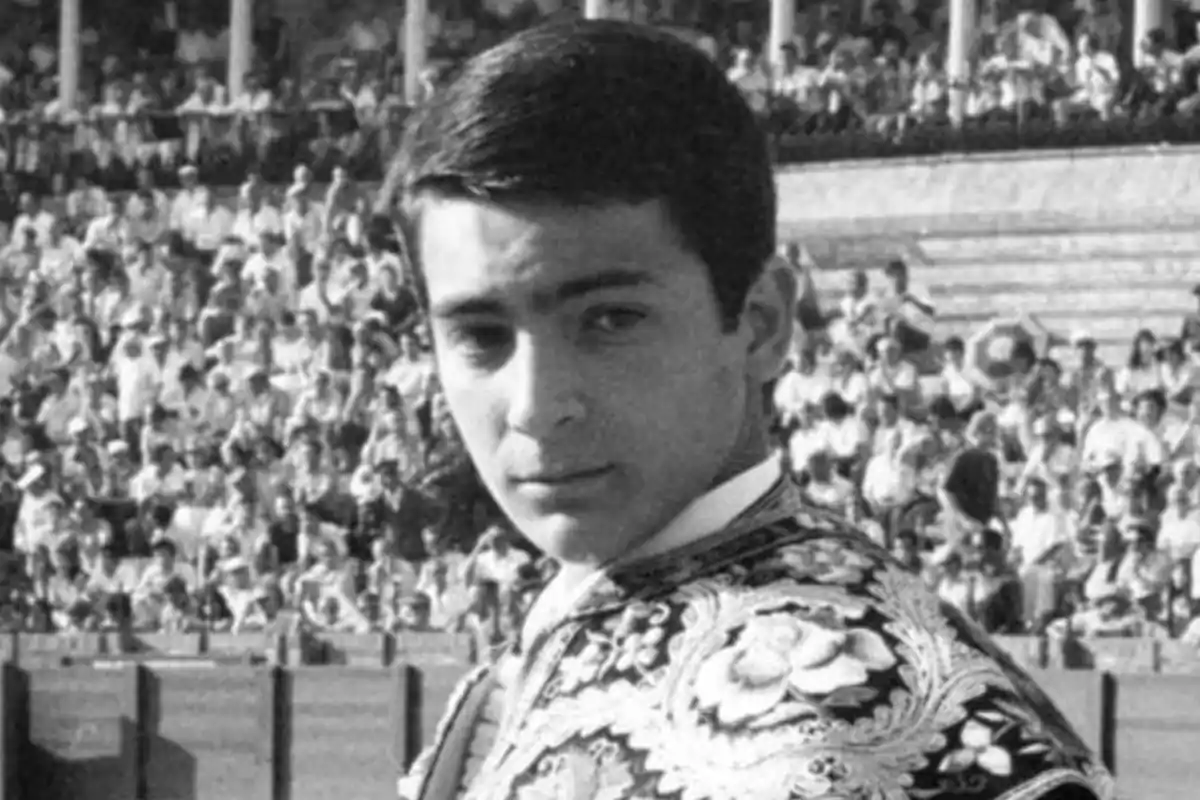 Joven torero vestido con traje de luces en una plaza de toros llena de espectadores Joven torero vestido con traje de luces en una plaza de toros llena de espectadores