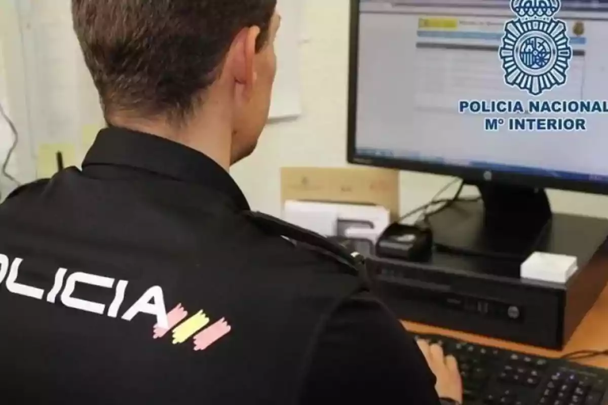 Un agente de la policía nacional trabaja en una computadora dentro de una oficina Un agente de la policía nacional trabaja en una computadora dentro de una oficina