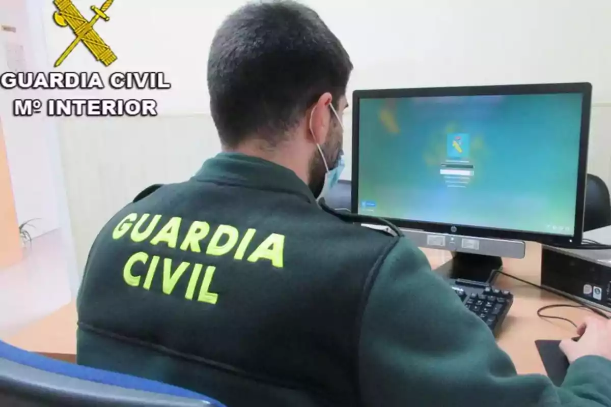 Agente de la Guardia Civil trabajando en una computadora en una oficina