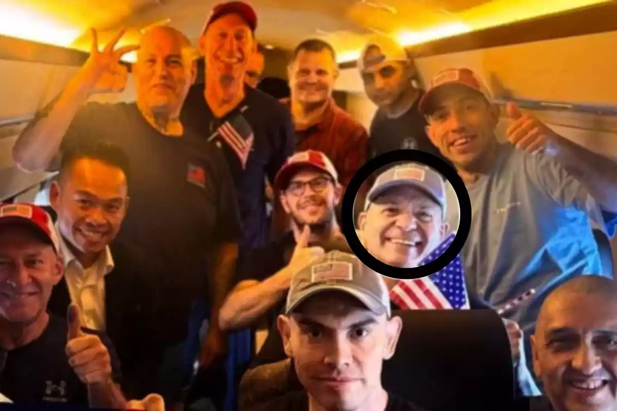 Un grupo de hombres sonríe y hace gestos de alegría dentro de un avión, varios llevan gorras y camisetas con banderas de Estados Unidos, uno de ellos está resaltado con un círculo negro Un grupo de hombres sonríe y hace gestos de alegría dentro de un avión, varios llevan gorras y camisetas con banderas de Estados Unidos, uno de ellos está resaltado con un círculo negro
