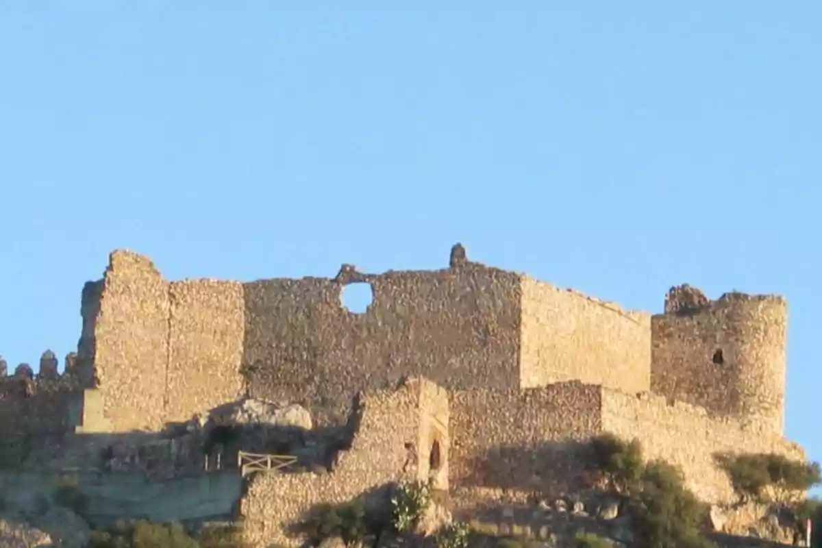 Ruinas de un castillo de piedra sobre una colina bajo un cielo despejado Ruinas de un castillo de piedra sobre una colina bajo un cielo despejado