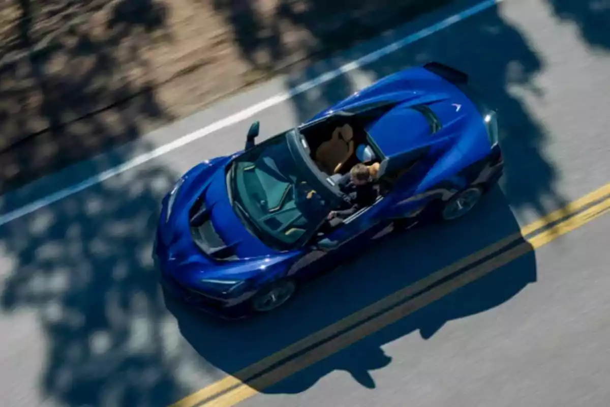Auto deportivo azul descapotable circulando por una carretera visto desde arriba Auto deportivo azul descapotable circulando por una carretera visto desde arriba