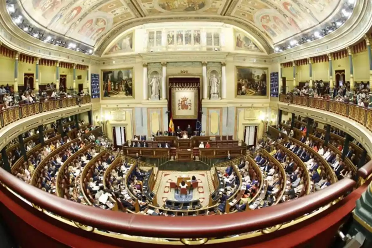 Vista panorámica del hemiciclo del Congreso de los Diputados de España durante una sesión parlamentaria con los escaños ocupados y la decoración histórica en las paredes y el techo