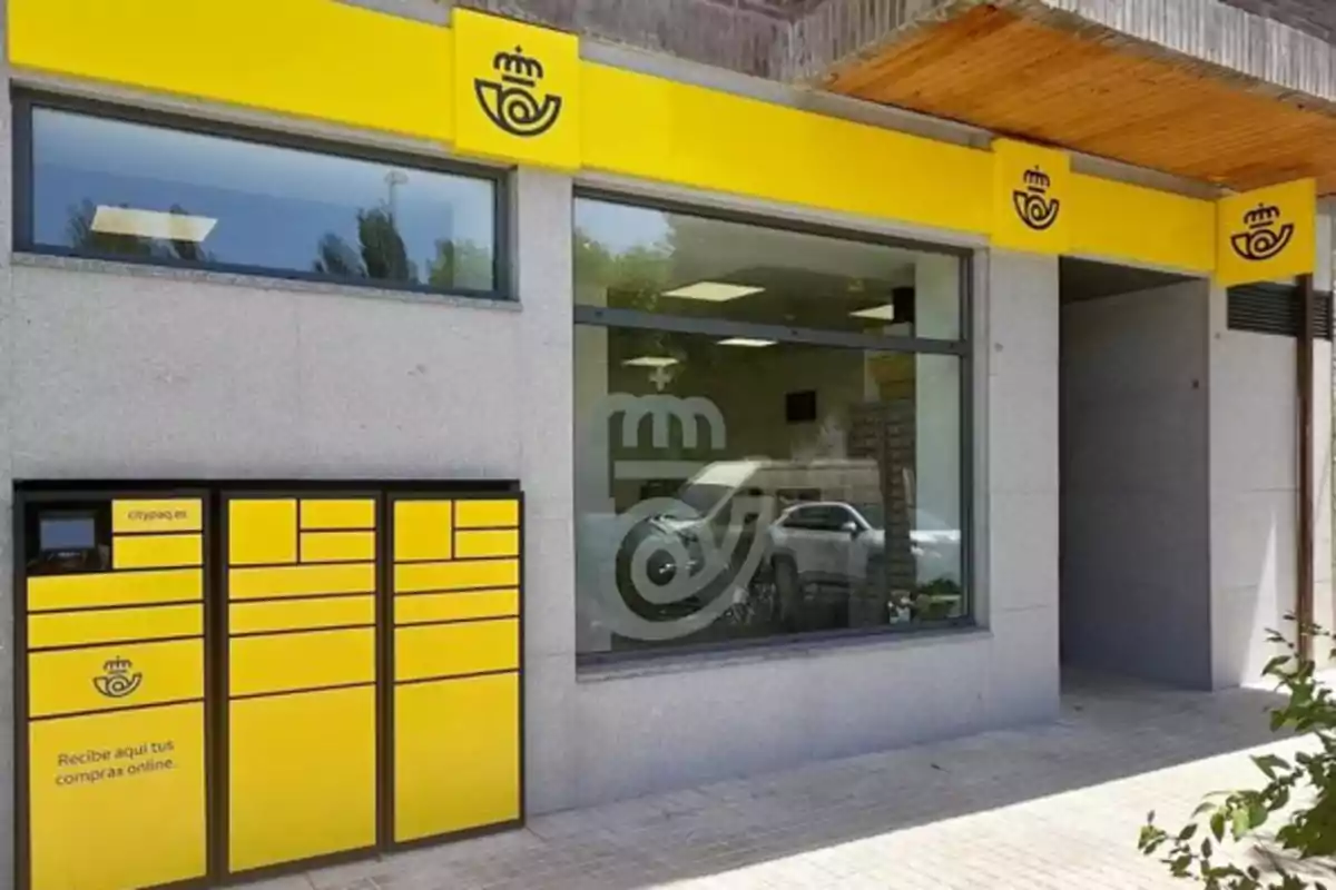 Oficina de correos con buzones amarillos para recoger paquetes y ventanales grandes Oficina de correos con buzones amarillos para recoger paquetes y ventanales grandes