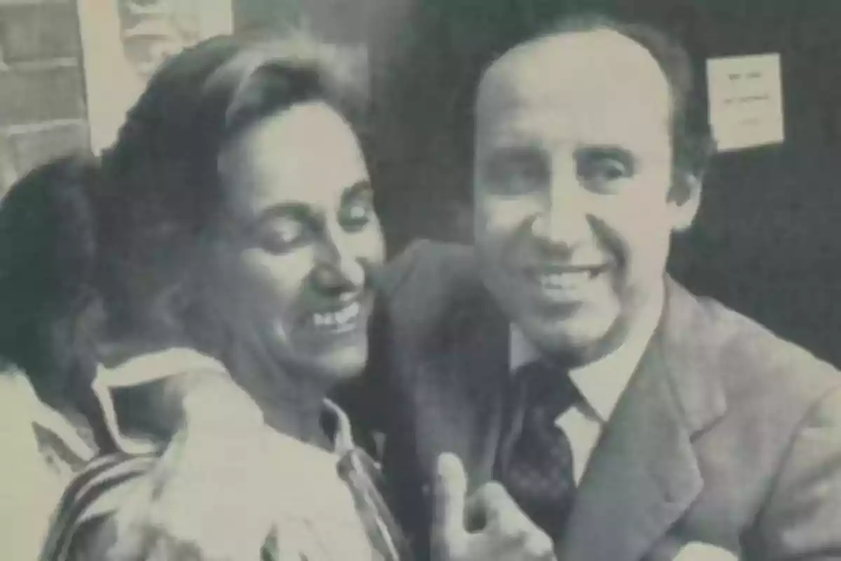 Dos personas sonríen y se abrazan en una fotografía en blanco y negro Dos personas sonríen y se abrazan en una fotografía en blanco y negro