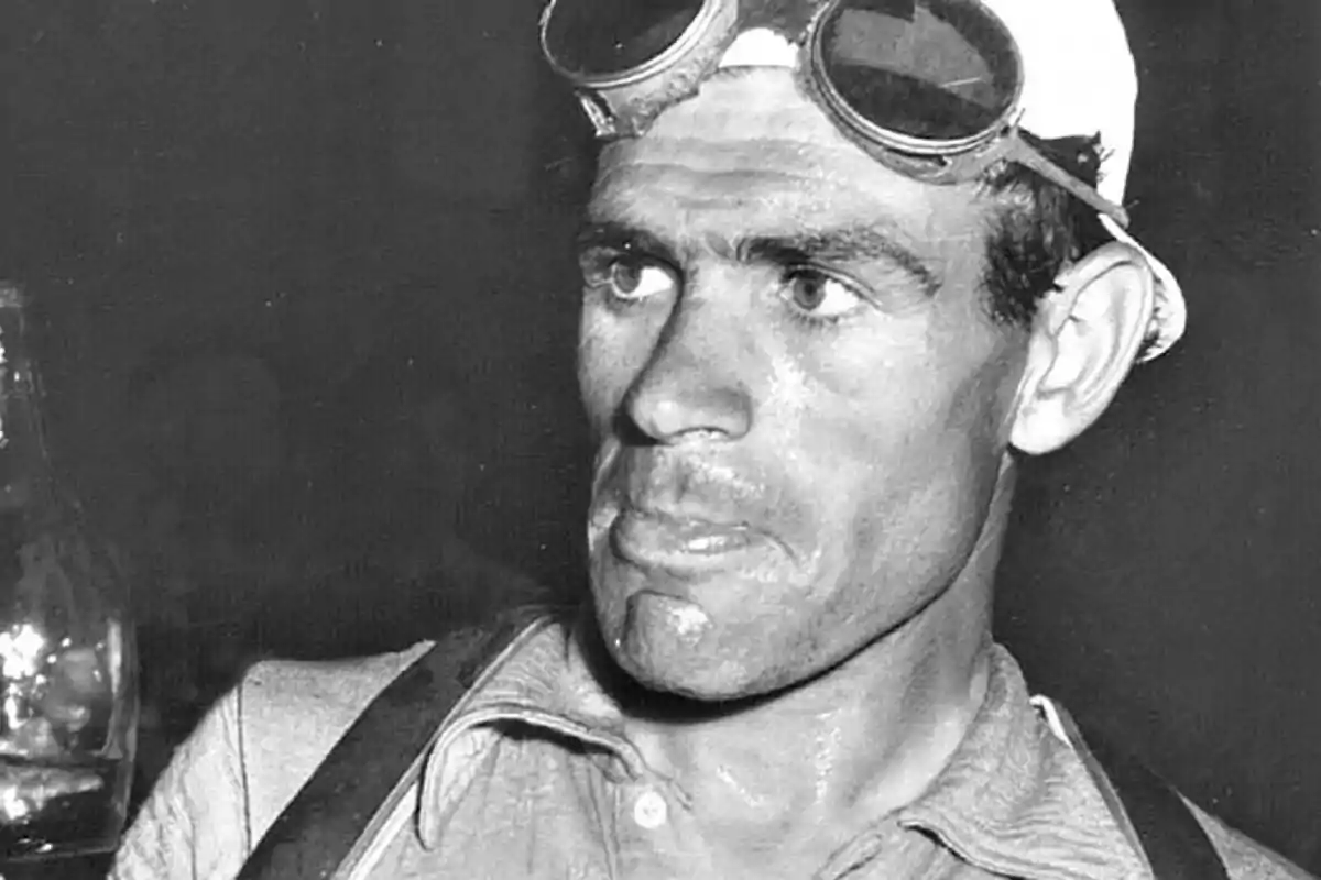 Hombre con gafas en la cabeza y expresión seria en una fotografía en blanco y negro Hombre con gafas en la cabeza y expresión seria en una fotografía en blanco y negro