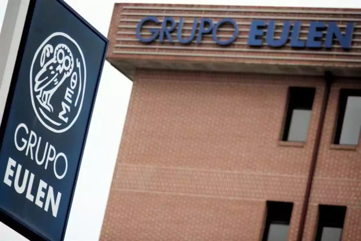 Edificio de ladrillo con el letrero y logotipo de Grupo Eulen en la fachada y en un cartel frontal Edificio de ladrillo con el letrero y logotipo de Grupo Eulen en la fachada y en un cartel frontal