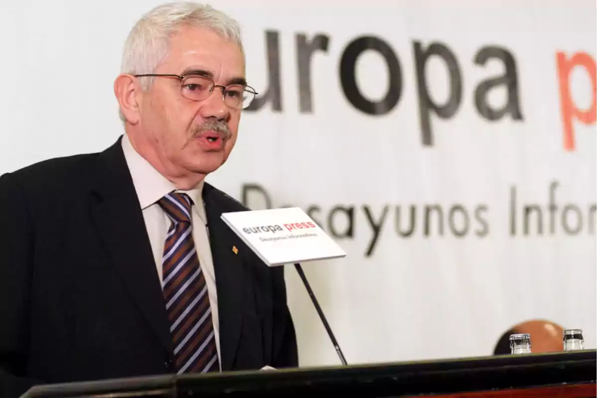 Hombre de cabello canoso y gafas hablando en un podio durante un evento de Europa Press Hombre de cabello canoso y gafas hablando en un podio durante un evento de Europa Press