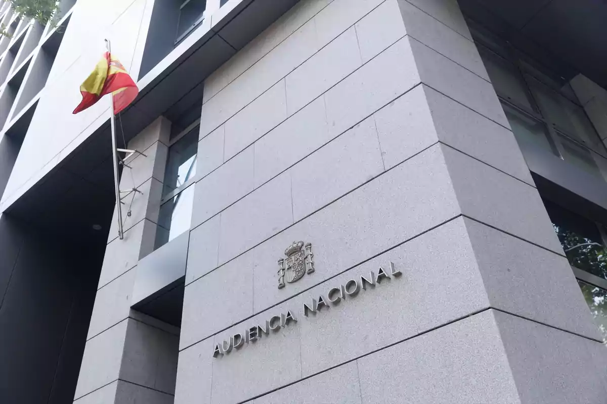 Fachada de un edificio gris con la bandera de España y el letrero Audiencia Nacional Fachada de un edificio gris con la bandera de España y el letrero Audiencia Nacional