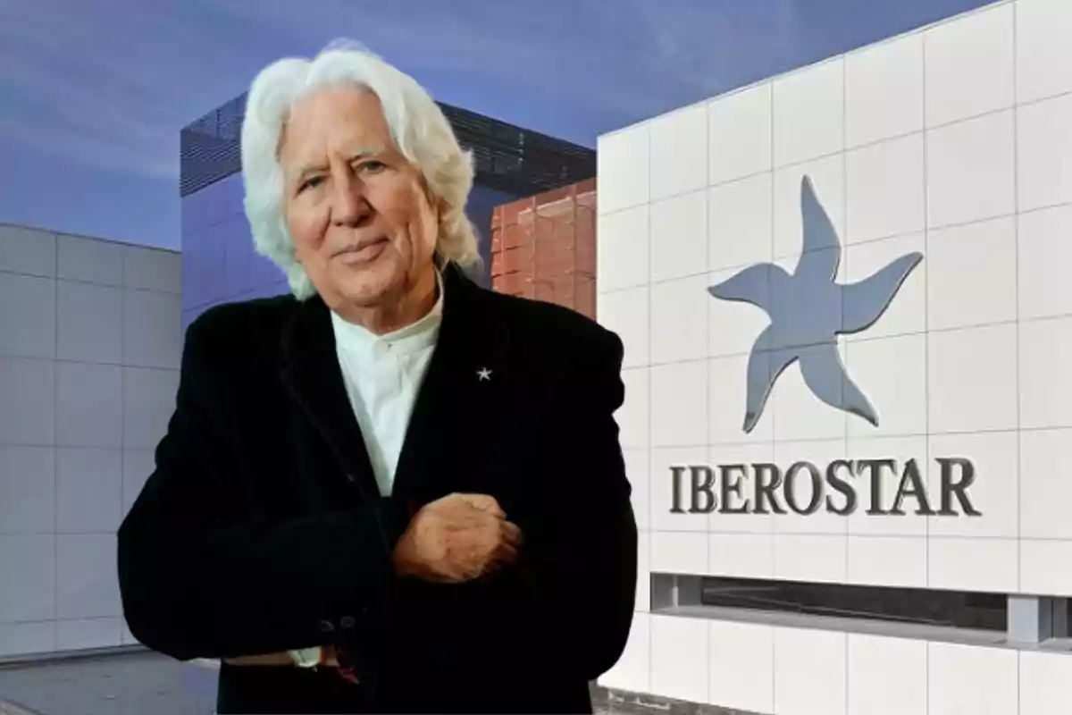 Hombre de cabello canoso y ropa oscura posando frente a un edificio moderno con el logo y nombre de Iberostar en la pared