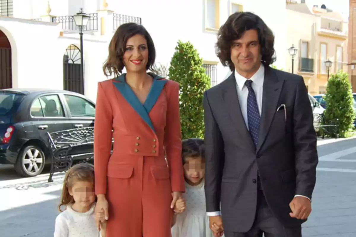 Familia elegantemente vestida caminando por la calle en un entorno urbano, con dos adultos y dos niñas pequeñas Familia elegantemente vestida caminando por la calle en un entorno urbano, con dos adultos y dos niñas pequeñas