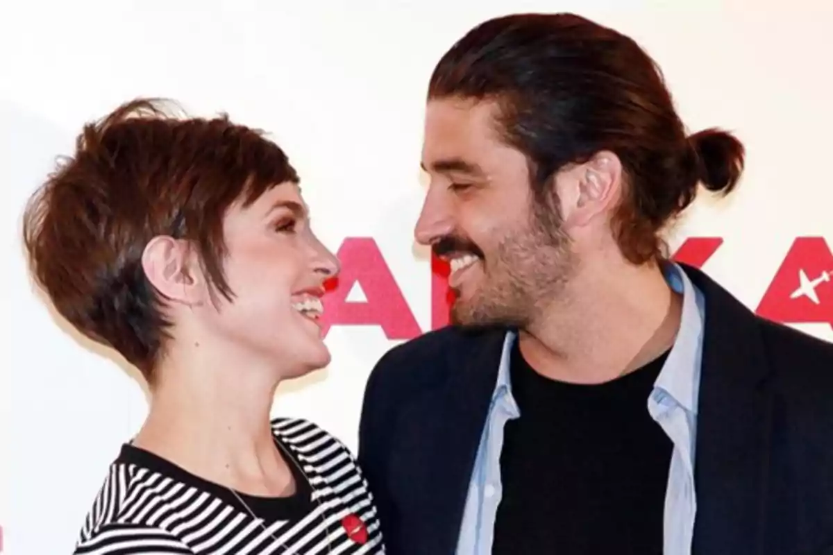 Pareja sonriendo y mirándose con cariño en un evento Pareja sonriendo y mirándose con cariño en un evento