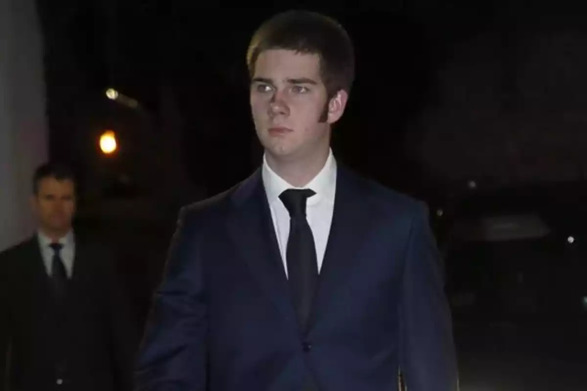 Young man in a blue suit and black tie walking at night with a serious expression Young man in a blue suit and black tie walking at night with a serious expression