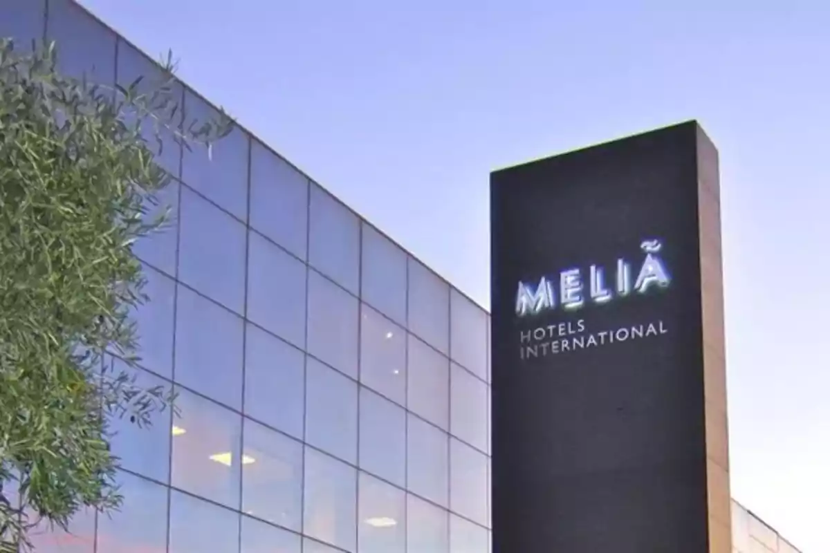 Fachada de un edificio moderno con un letrero de Meliá Hotels International al atardecer Fachada de un edificio moderno con un letrero de Meliá Hotels International al atardecer