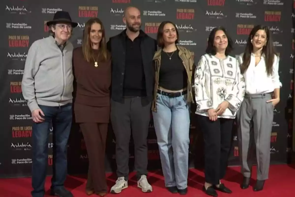 Seis personas posan sonrientes sobre una alfombra roja frente a un fondo con logotipos de un evento llamado Paco de Lucía Legacy. Seis personas posan sonrientes sobre una alfombra roja frente a un fondo con logotipos de un evento llamado Paco de Lucía Legacy.