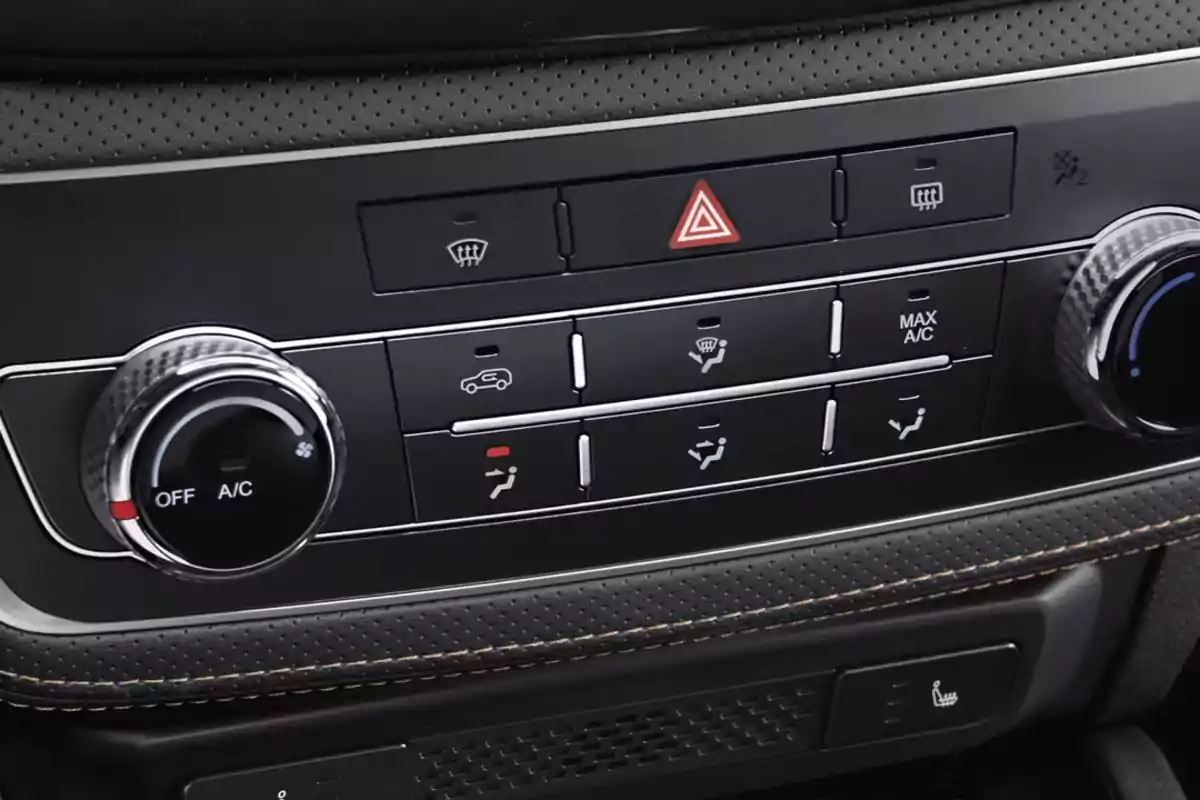 Controles del sistema de aire acondicionado y calefacción de un automóvil con botones y perillas plateadas Controles del sistema de aire acondicionado y calefacción de un automóvil con botones y perillas plateadas