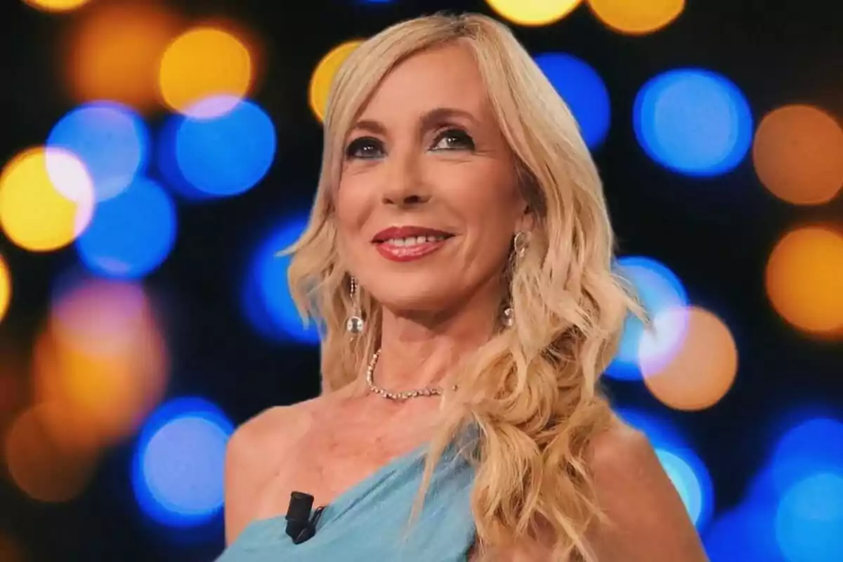 Mujer rubia con vestido azul claro y fondo de luces desenfocadas en tonos azules y naranjas Mujer rubia con vestido azul claro y fondo de luces desenfocadas en tonos azules y naranjas