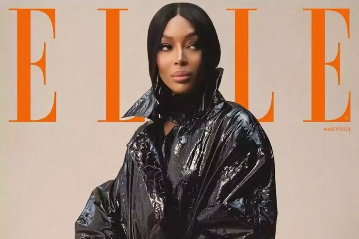 Portada de revista de moda con una mujer usando un abrigo negro brillante y fondo beige con letras grandes en color naranja