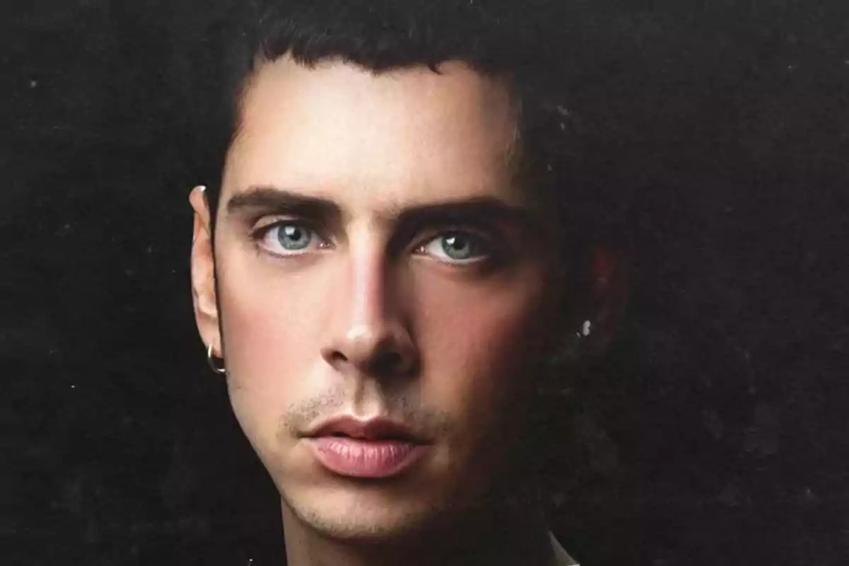 Retrato de un hombre joven de ojos claros con cabello corto y oscuro, fondo negro Retrato de un hombre joven de ojos claros con cabello corto y oscuro, fondo negro