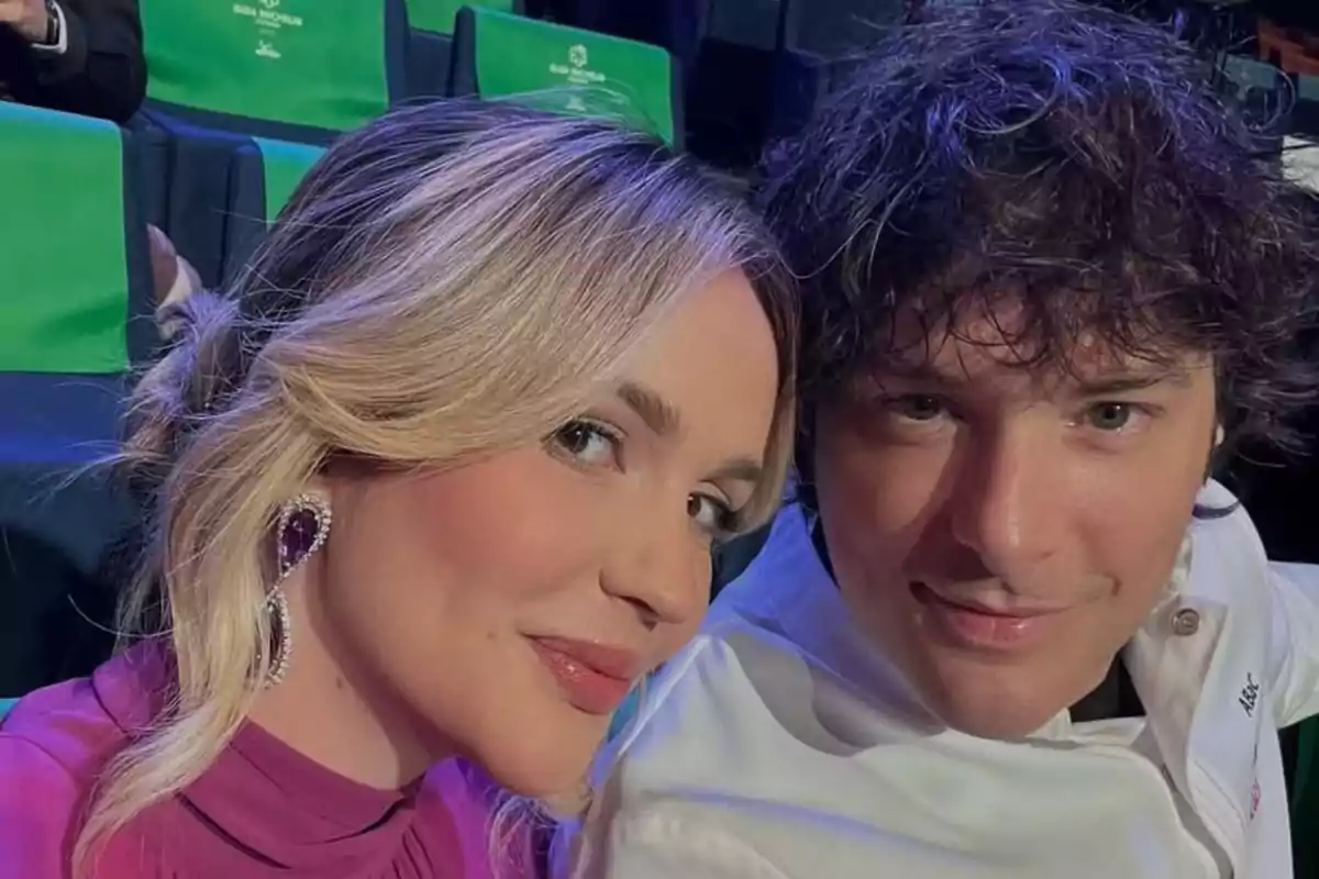 Una mujer y un hombre posan juntos para una selfie en un lugar con asientos verdes Una mujer y un hombre posan juntos para una selfie en un lugar con asientos verdes
