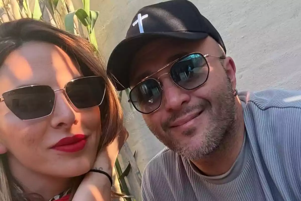 Pareja tomándose una selfie al aire libre ambos usando gafas de sol y sonriendo Pareja tomándose una selfie al aire libre ambos usando gafas de sol y sonriendo