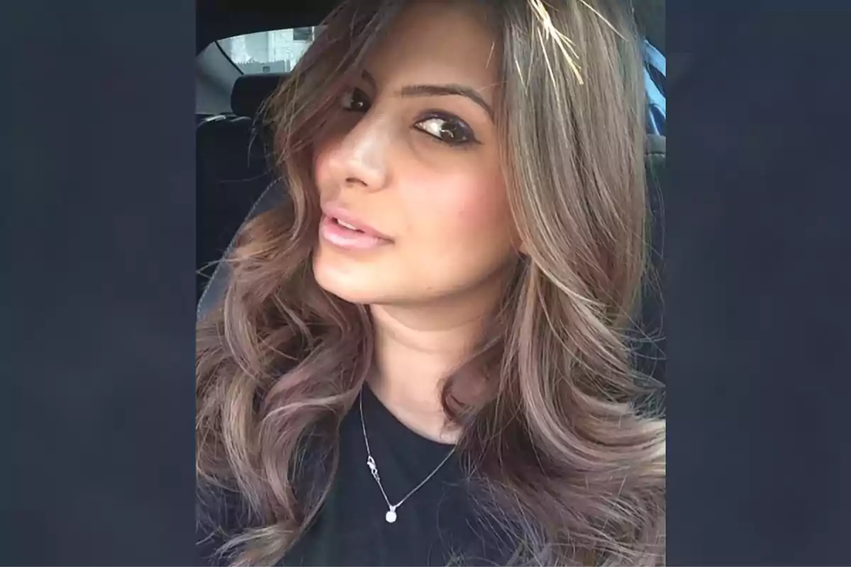 Mujer con cabello largo y ondulado mirando hacia la cámara dentro de un automóvil Mujer con cabello largo y ondulado mirando hacia la cámara dentro de un automóvil