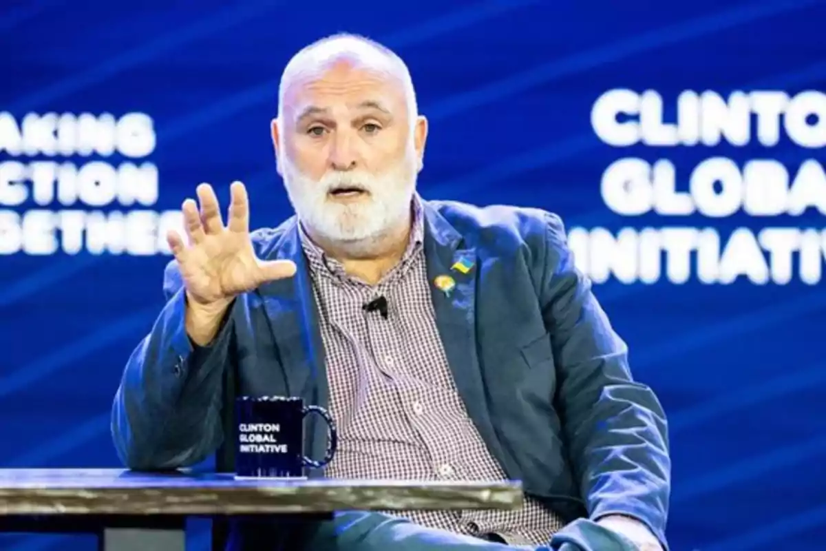 Hombre de barba blanca hablando en un escenario con fondo azul y letras blancas que dicen Clinton Global Initiative mientras sostiene una mano levantada y una taza sobre la mesa Hombre de barba blanca hablando en un escenario con fondo azul y letras blancas que dicen Clinton Global Initiative mientras sostiene una mano levantada y una taza sobre la mesa