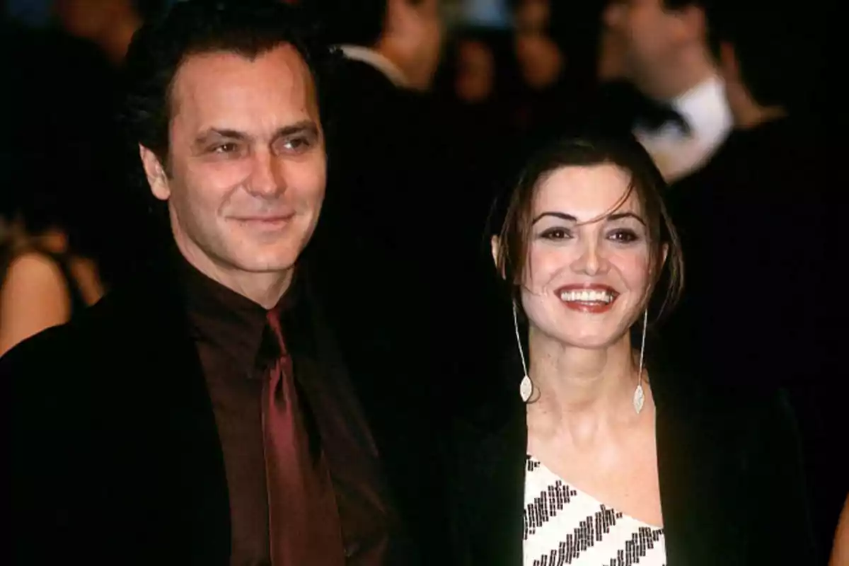 Pareja sonriente vestida de manera elegante en un evento nocturno