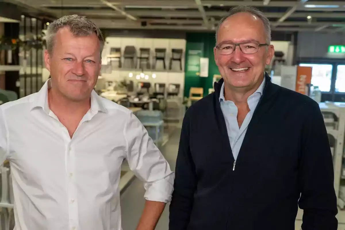 Dos hombres sonrientes posan en el interior de una tienda de muebles Dos hombres sonrientes posan en el interior de una tienda de muebles