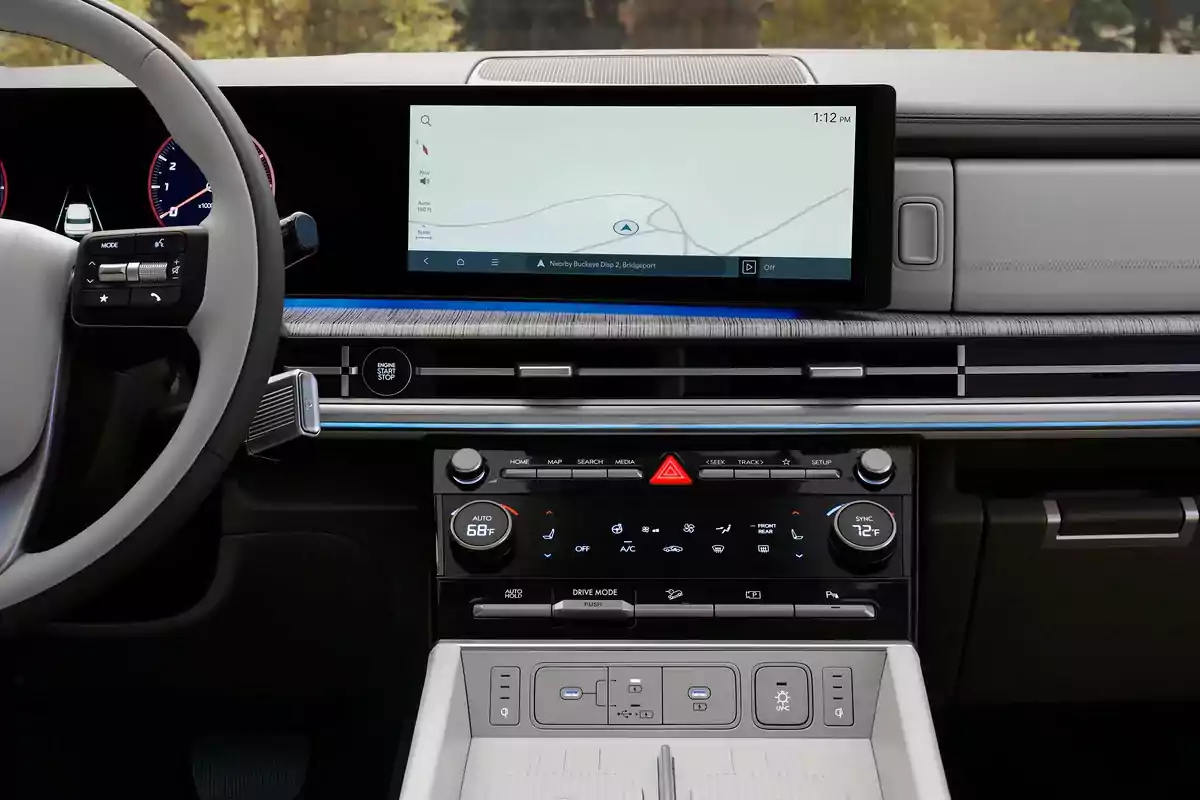 Interior de un automóvil moderno con pantalla de navegación encendida, controles de clima digitales y volante multifunción Interior de un automóvil moderno con pantalla de navegación encendida, controles de clima digitales y volante multifunción