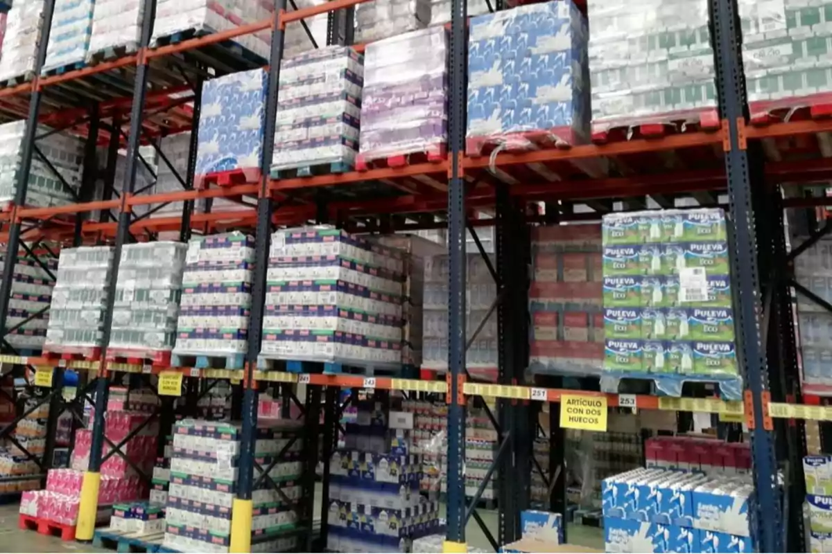 Estantes de almacén industrial llenos de productos apilados en pallets Estantes de almacén industrial llenos de productos apilados en pallets