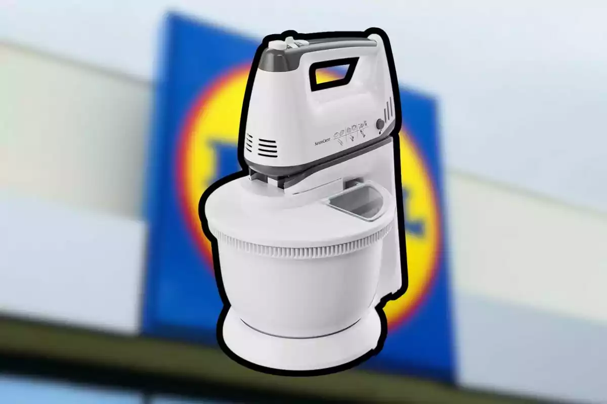 Batidora blanca con base y tazón frente a un fondo desenfocado de una tienda Lidl Batidora blanca con base y tazón frente a un fondo desenfocado de una tienda Lidl