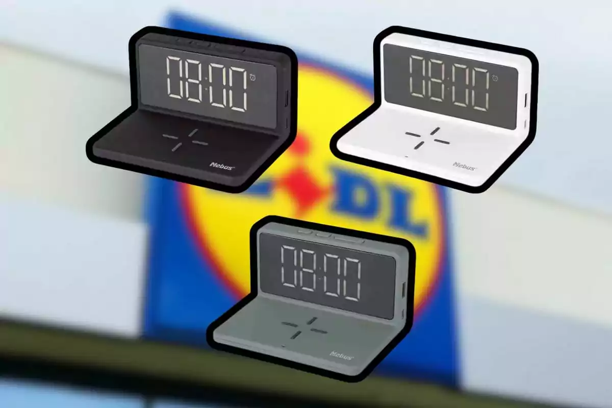 Tres relojes despertadores digitales en colores negro, blanco y gris con base para carga inalámbrica, sobre un fondo desenfocado con el logo de Lidl. Tres relojes despertadores digitales en colores negro, blanco y gris con base para carga inalámbrica, sobre un fondo desenfocado con el logo de Lidl.