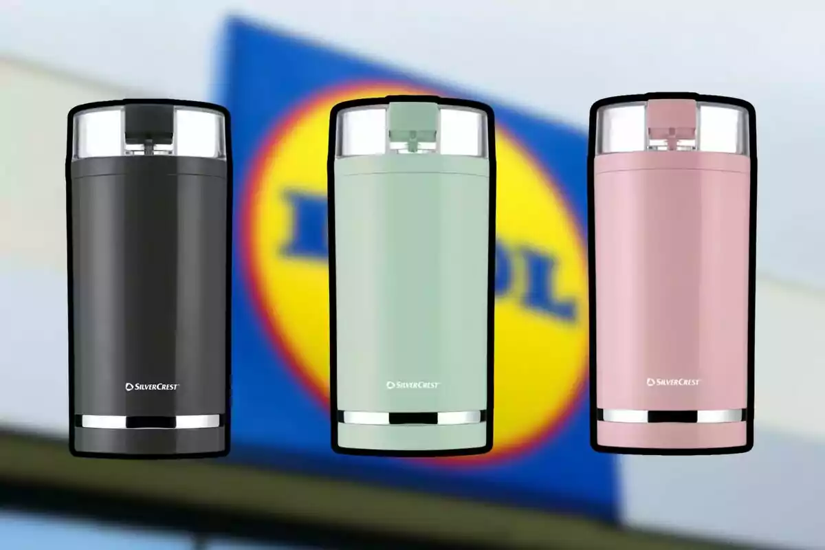 Tres termos de colores negro, verde y rosa de la marca SilverCrest frente a un cartel borroso de Lidl Tres termos de colores negro, verde y rosa de la marca SilverCrest frente a un cartel borroso de Lidl