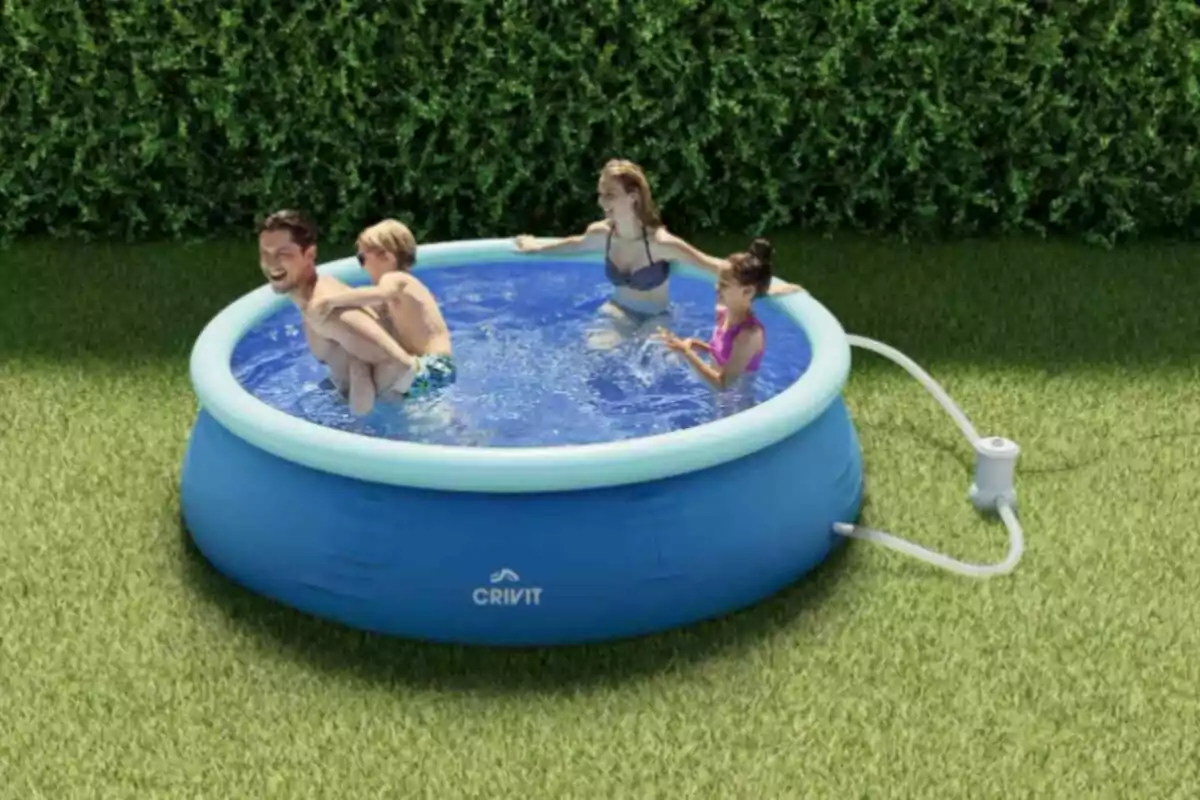Una familia se divierte en una piscina inflable azul ubicada en un jardín con césped y setos verdes al fondo Una familia se divierte en una piscina inflable azul ubicada en un jardín con césped y setos verdes al fondo
