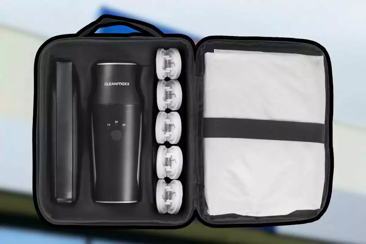 Estuche negro abierto que contiene una aspiradora portátil CLEANmaxx con accesorios y una bolsa blanca sujeta con una banda elástica Estuche negro abierto que contiene una aspiradora portátil CLEANmaxx con accesorios y una bolsa blanca sujeta con una banda elástica