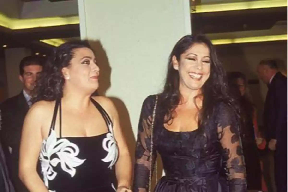 Dos mujeres vestidas de gala sonríen mientras caminan juntas en un evento social Dos mujeres vestidas de gala sonríen mientras caminan juntas en un evento social