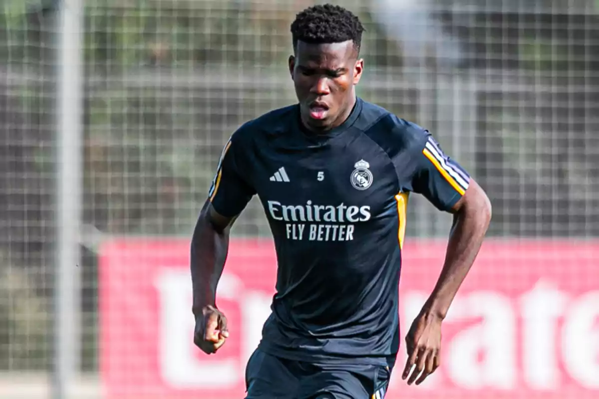 Futbolista del Real Madrid entrenando con el uniforme de entrenamiento negro en un campo de fútbol Futbolista del Real Madrid entrenando con el uniforme de entrenamiento negro en un campo de fútbol