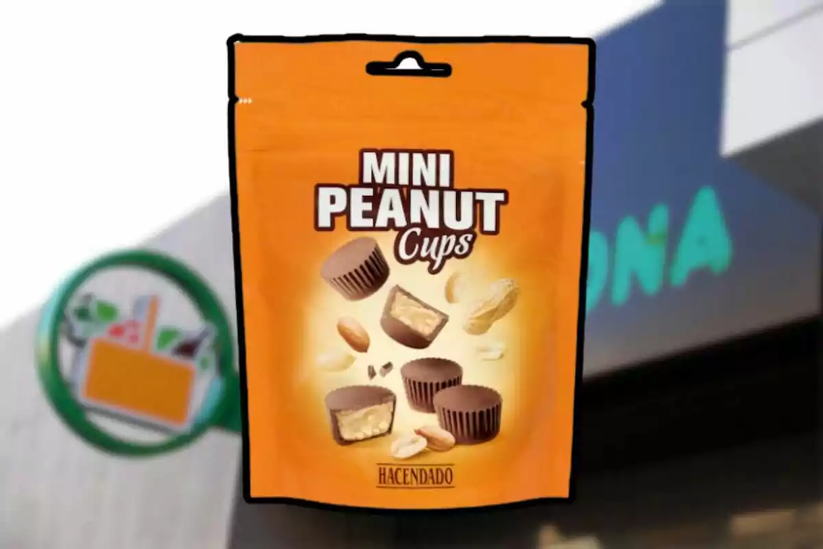 Bolsa naranja de Mini Peanut Cups de la marca Hacendado frente a una tienda Mercadona desenfocada Bolsa naranja de Mini Peanut Cups de la marca Hacendado frente a una tienda Mercadona desenfocada